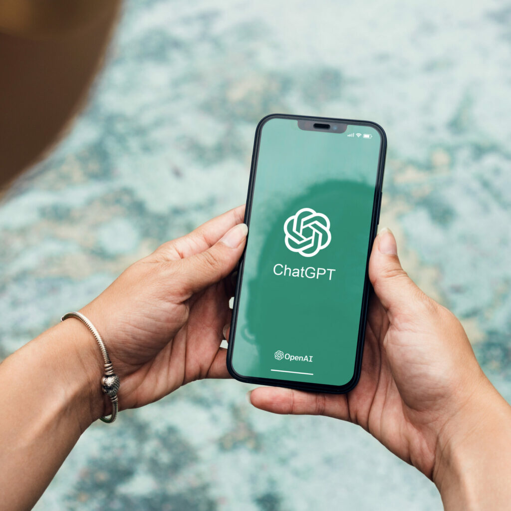 girl in the park holding a smartphone with chatgpt artificial in